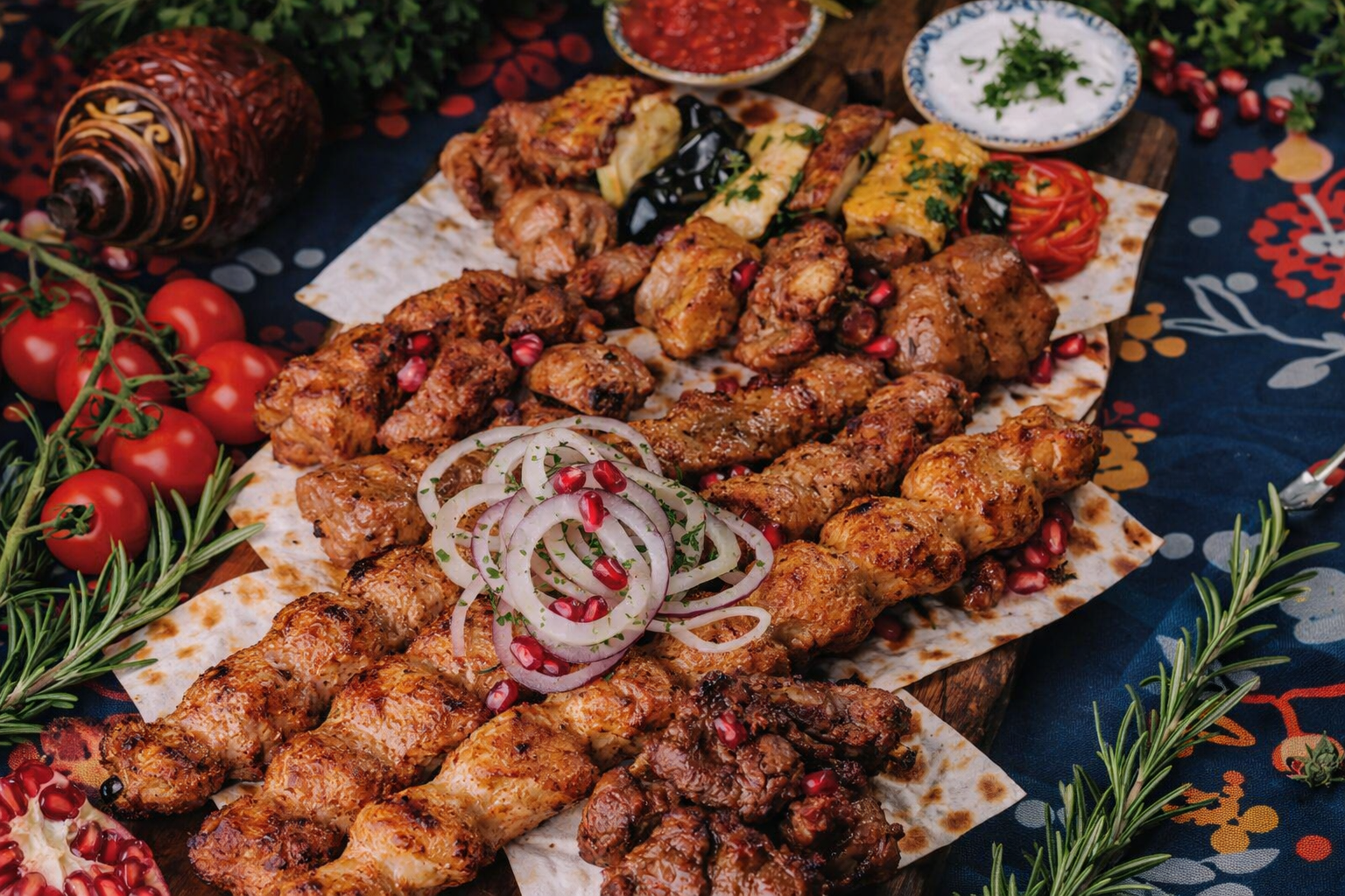 Grilled meat skewers with onions and herbs on a decorative tablecloth