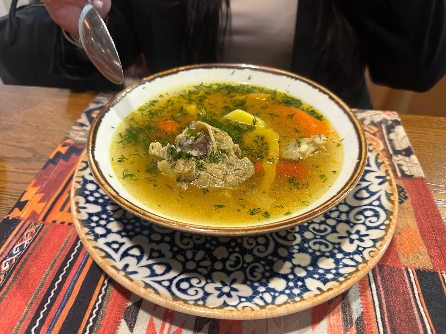 Traditional soup served in decorative ceramic bowl with herb garnish