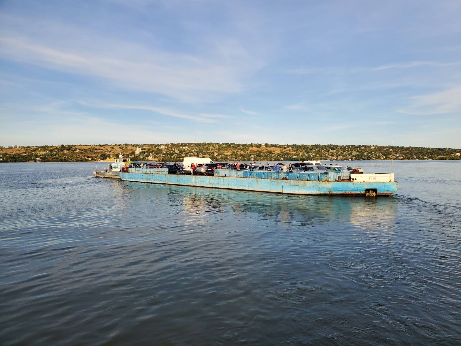 River cruise boat on calm waterway with coastal town in background
