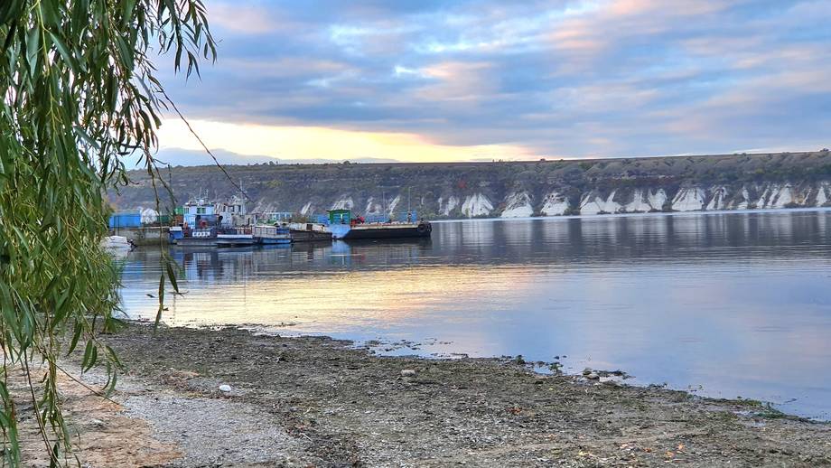Riverfront location with boats and dramatic chalk cliffs across the water at sunrise