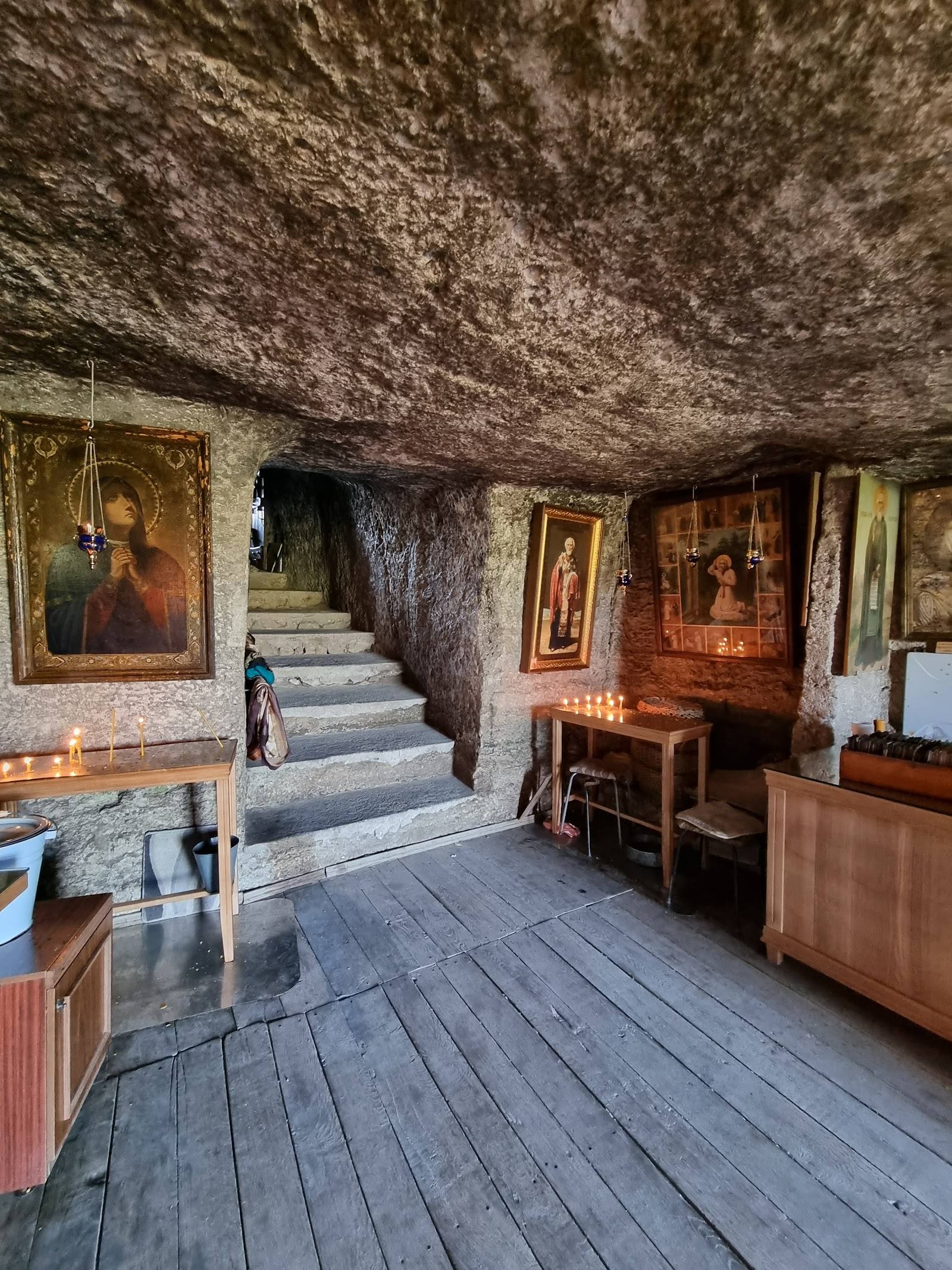 Rustic monastery or chapel interior with wooden beams, icon paintings, and traditional furnishings