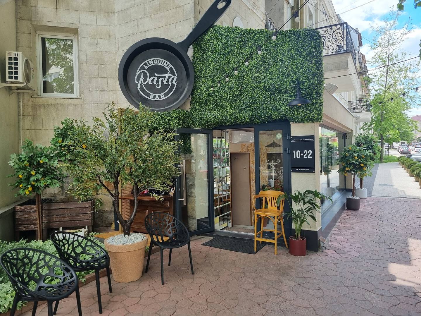 Charming storefront with frying pan sign, terrace seating, and welcoming entrance
