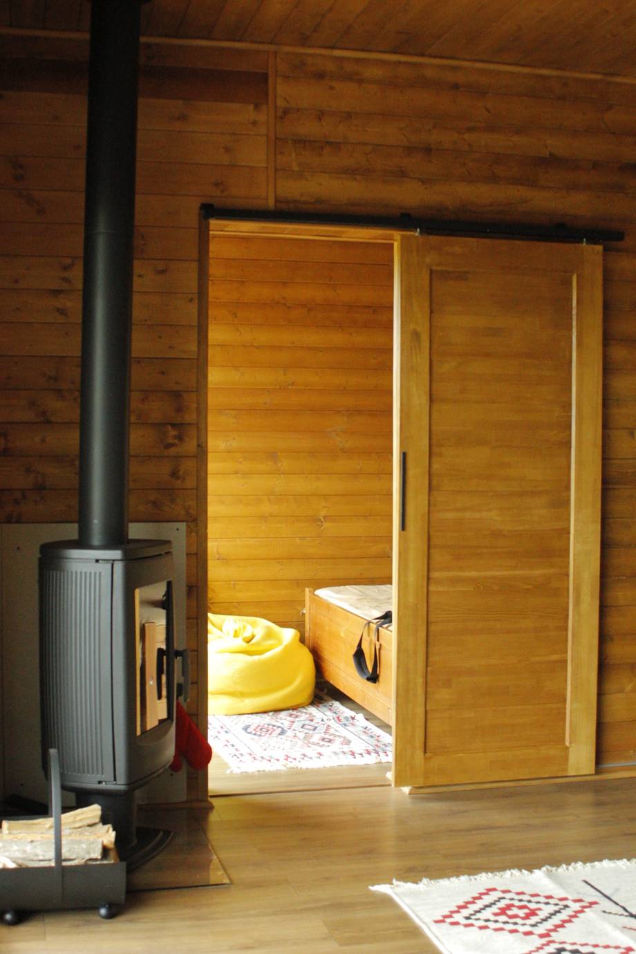 Sauna interior with wooden doors, bench seating and wood-burning stove