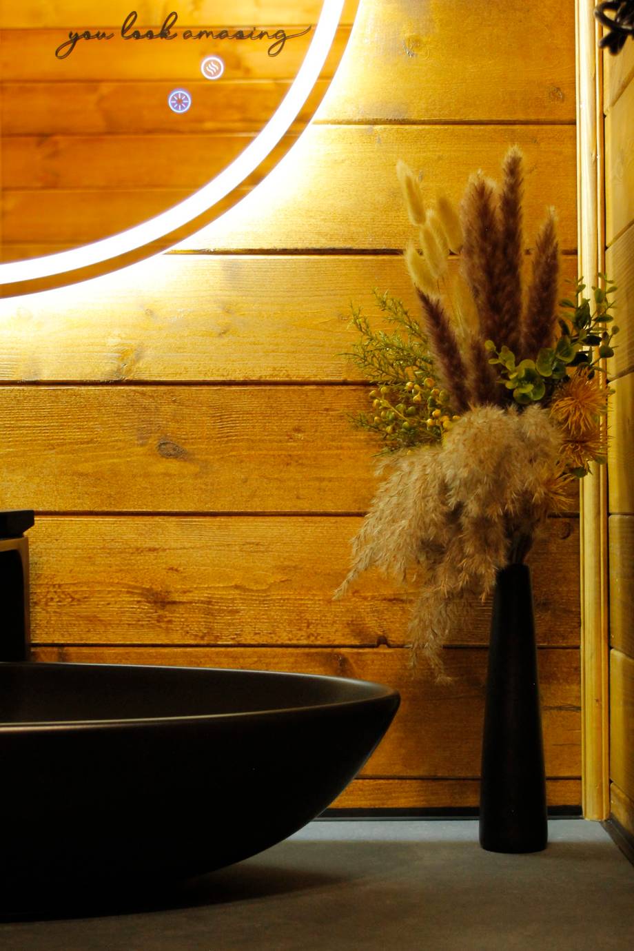 Modern spa treatment room with wooden accent wall and neon sign detail