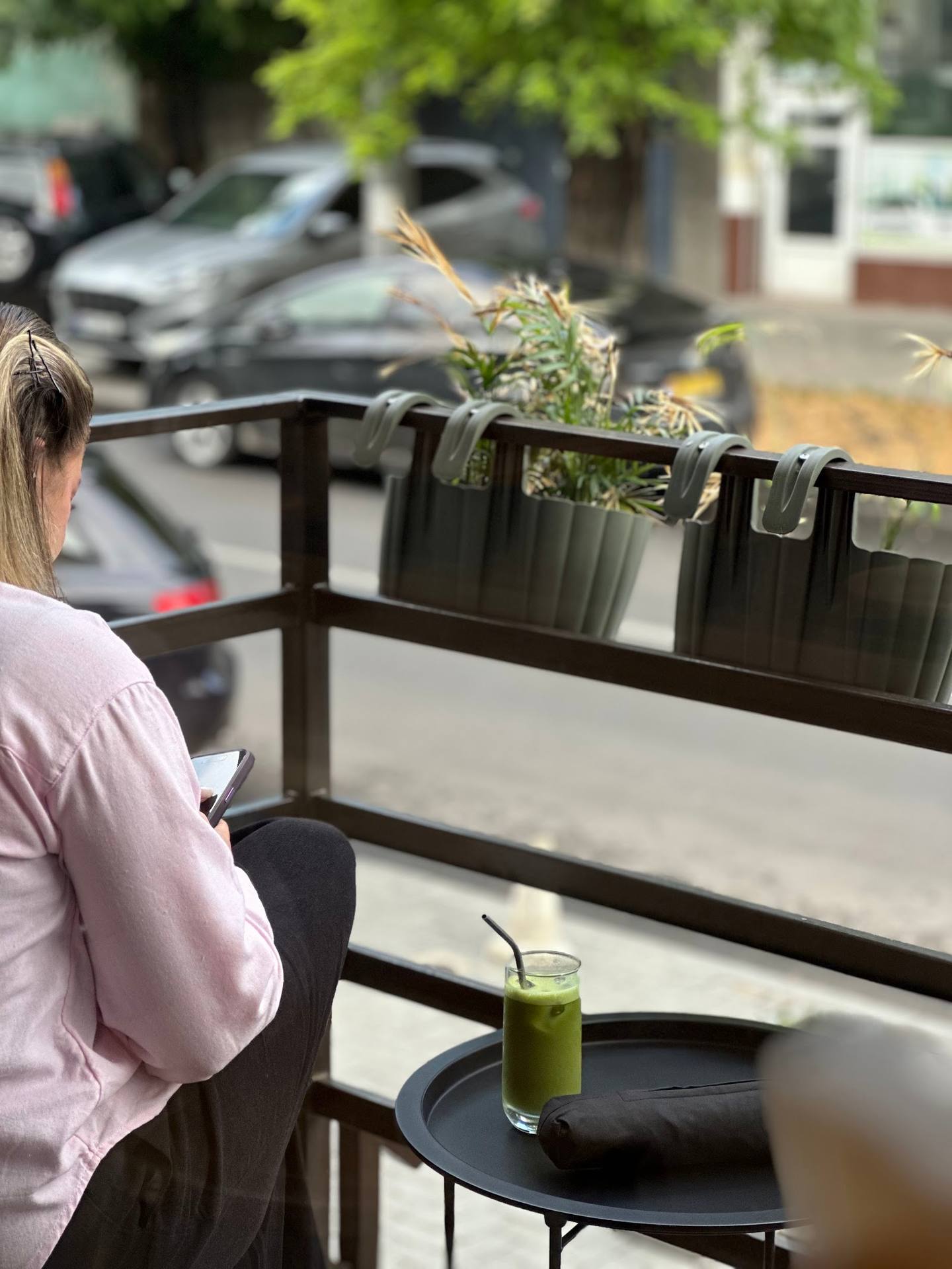 Outdoor terrace seating with green juice and street view