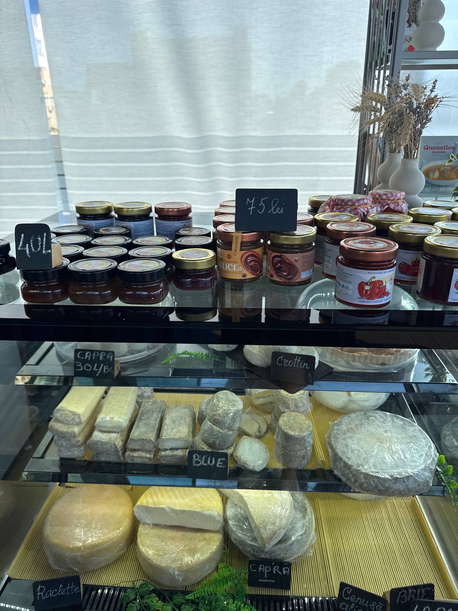 Artisanal cheese and preserve display with labeled selections in shop window