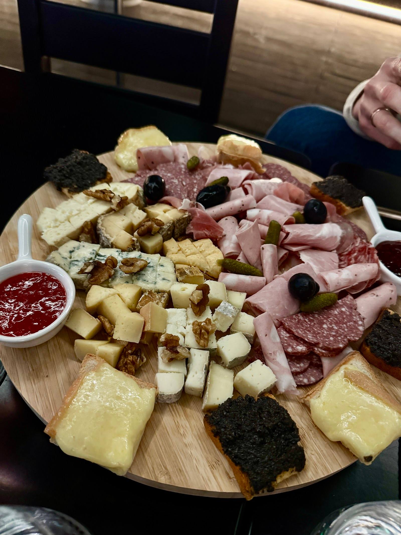 Charcuterie and cheese board with cured meats, olives, and jam