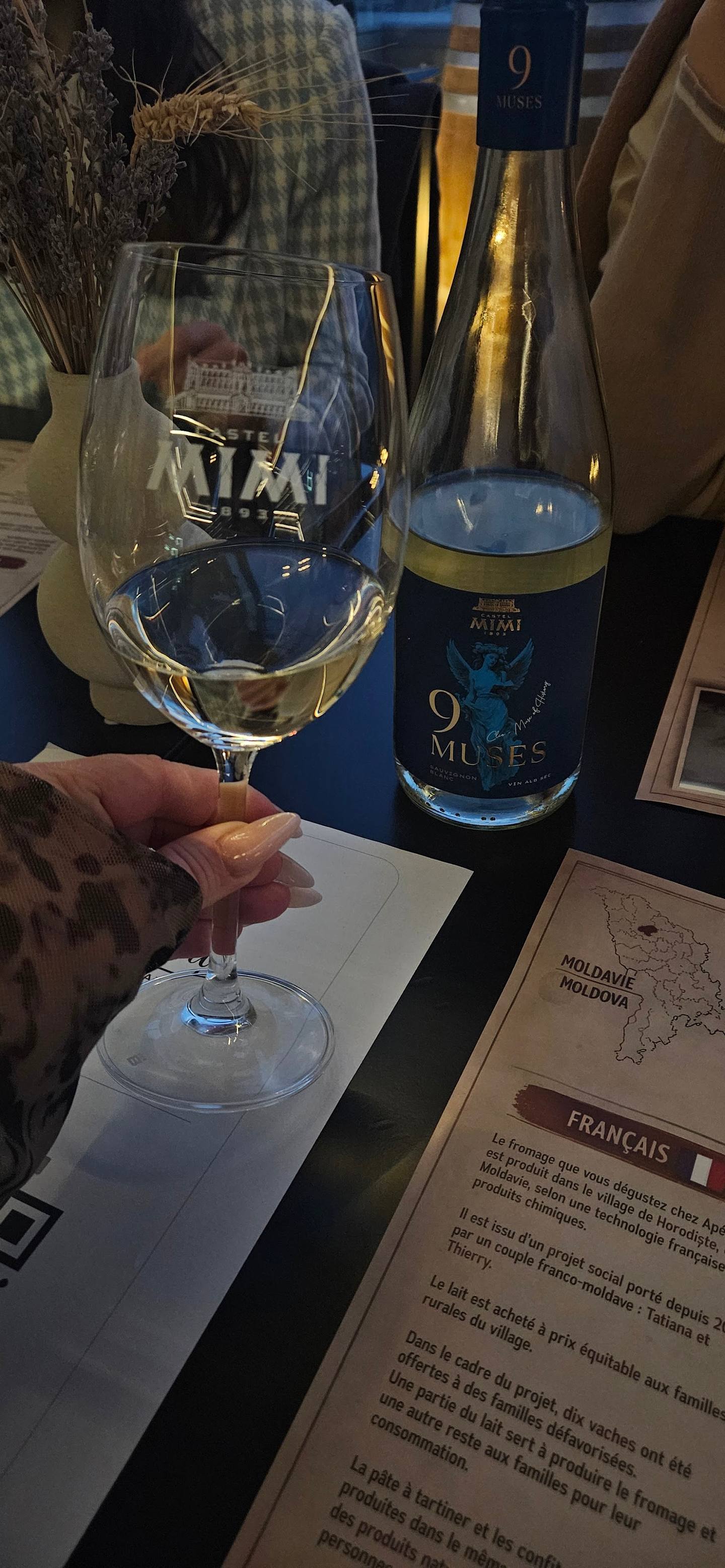 White wine glass with Aïtai winery bottle and tasting notes visible