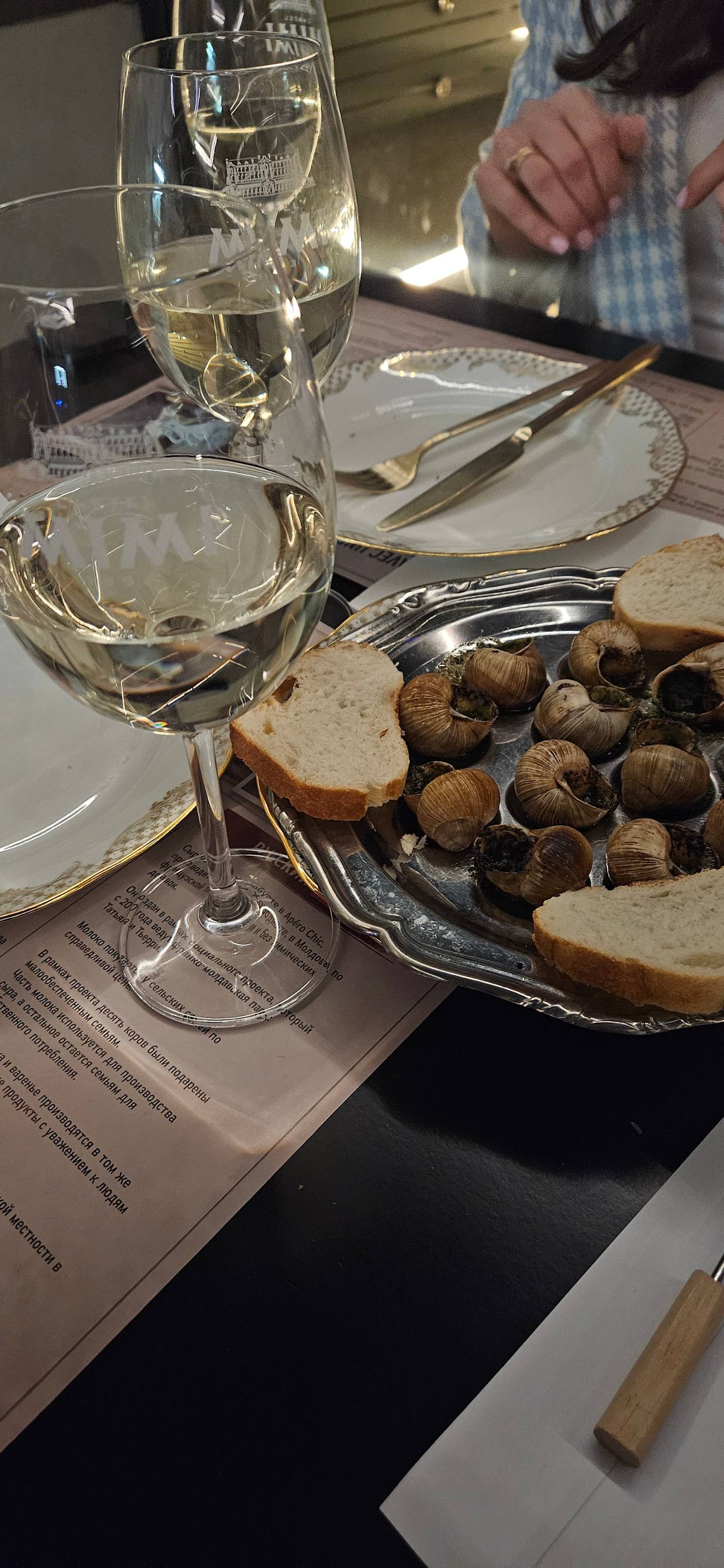 Wine and snacks table setting with white wine glasses and bread basket