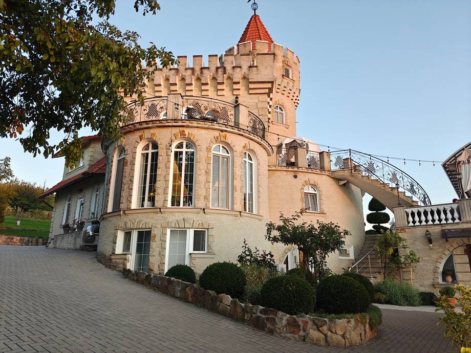 Historic fortress with distinctive red-tiled turret and crenellated walls, main exterior facade