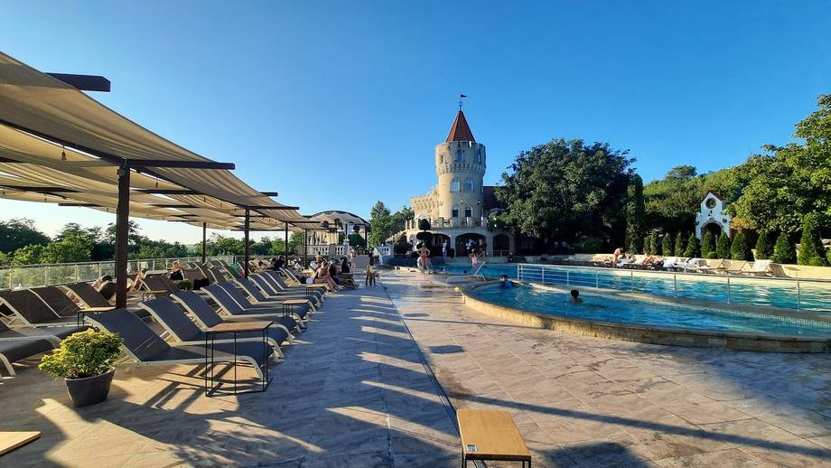 Terrace with sunbeds overlooking swimming pool and distinctive tower landmark