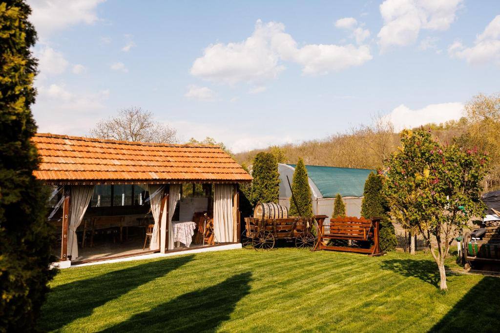 Rustic wooden pavilion with terrace overlooking landscaped gardens and pond