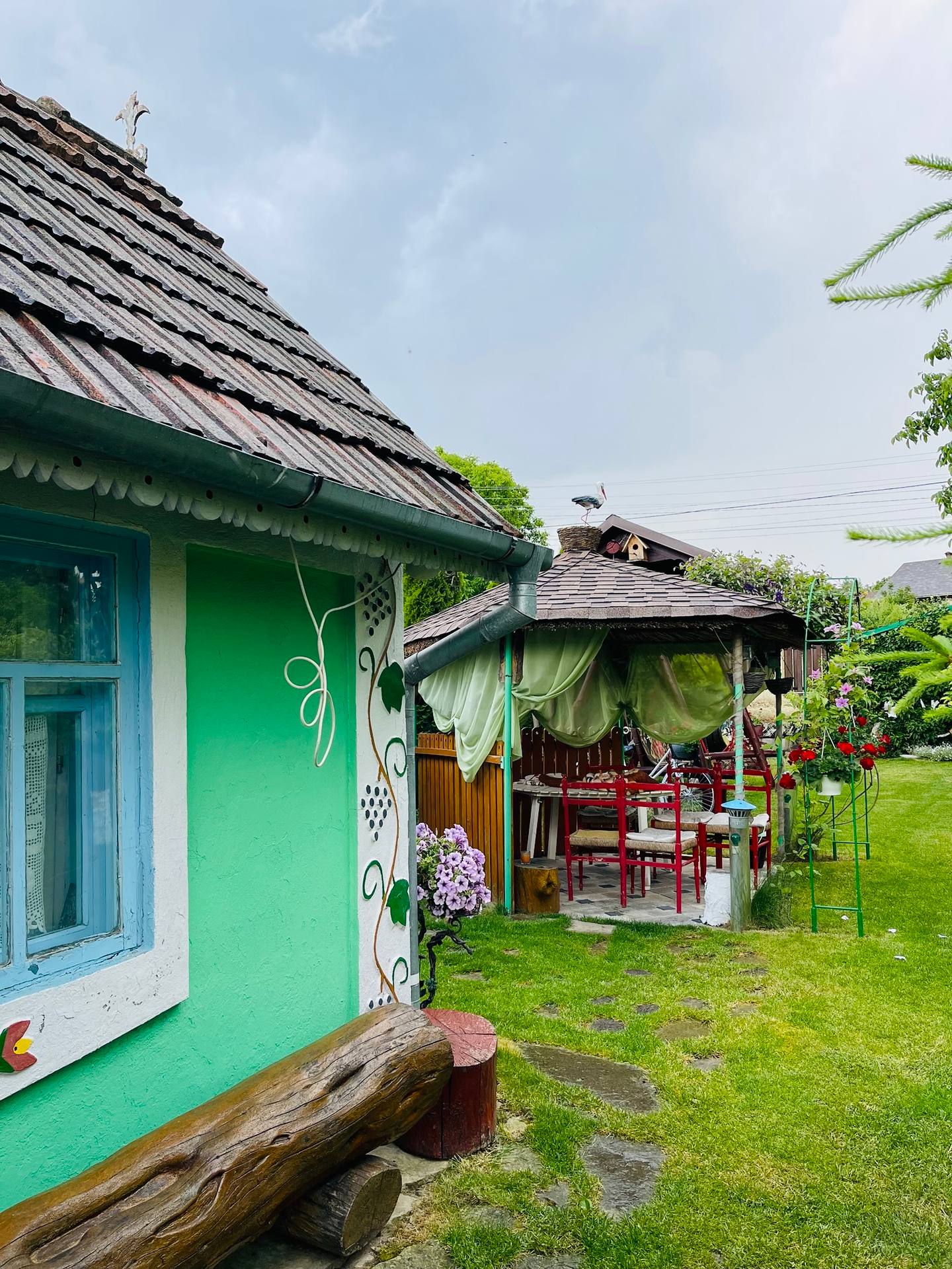 Charming green cottage with rustic terrace pavilion and manicured grounds