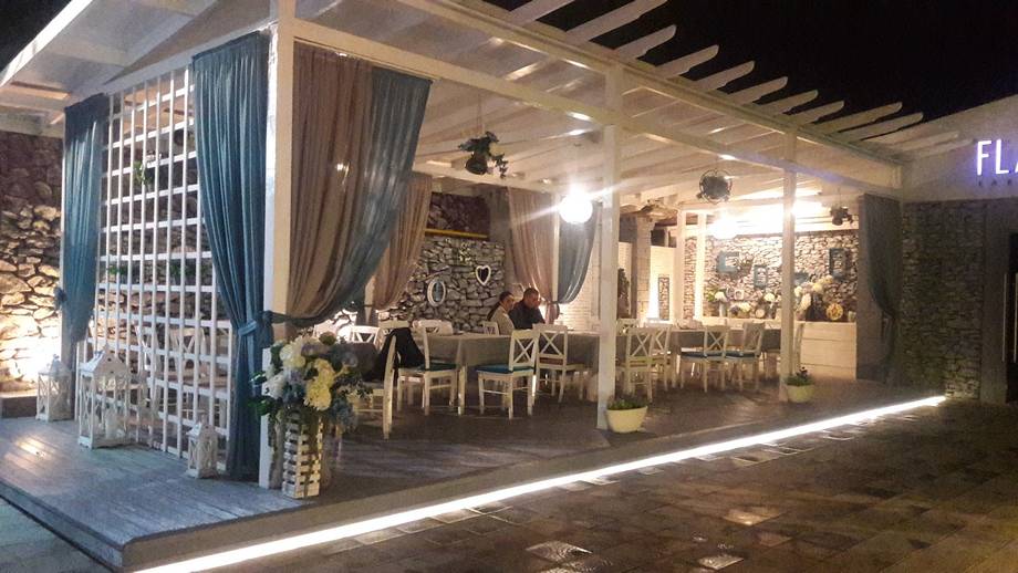 Event venue storefront with elegant facade, seating area, and ambient lighting at night