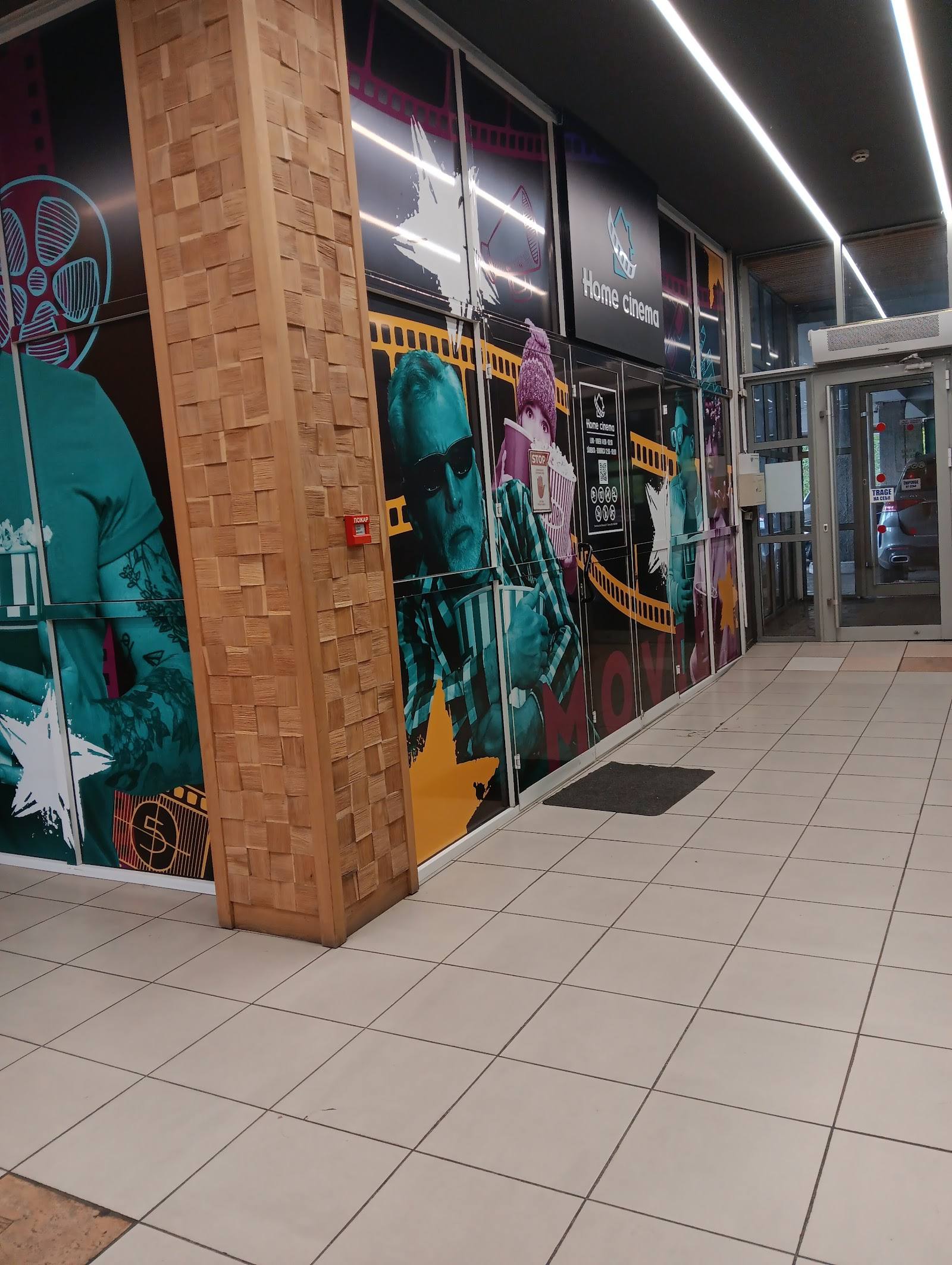 Colorful storefront with brick column and modern commercial signage in shopping corridor