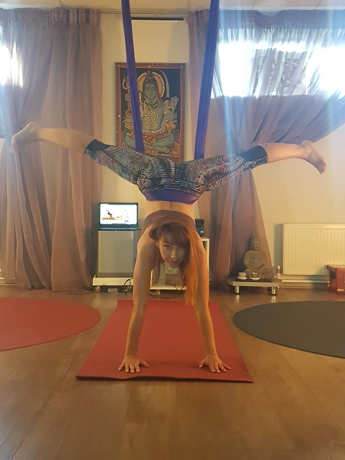 Yoga instructor demonstrating advanced inversion pose in studio space