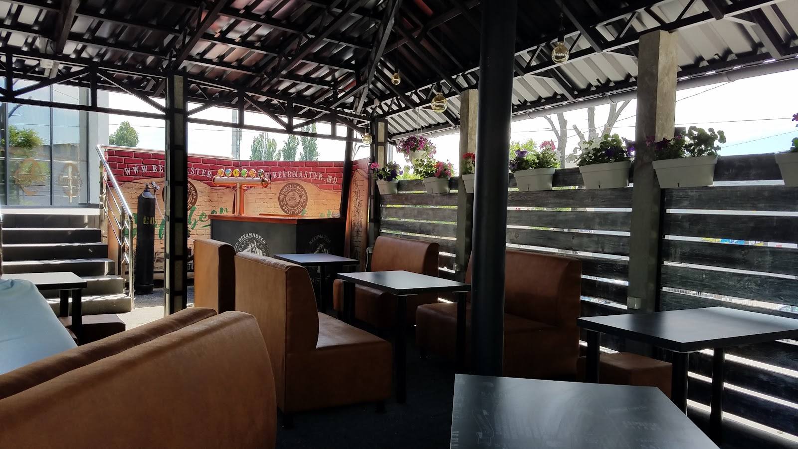 Covered terrace with seating, wooden screens, and countryside views