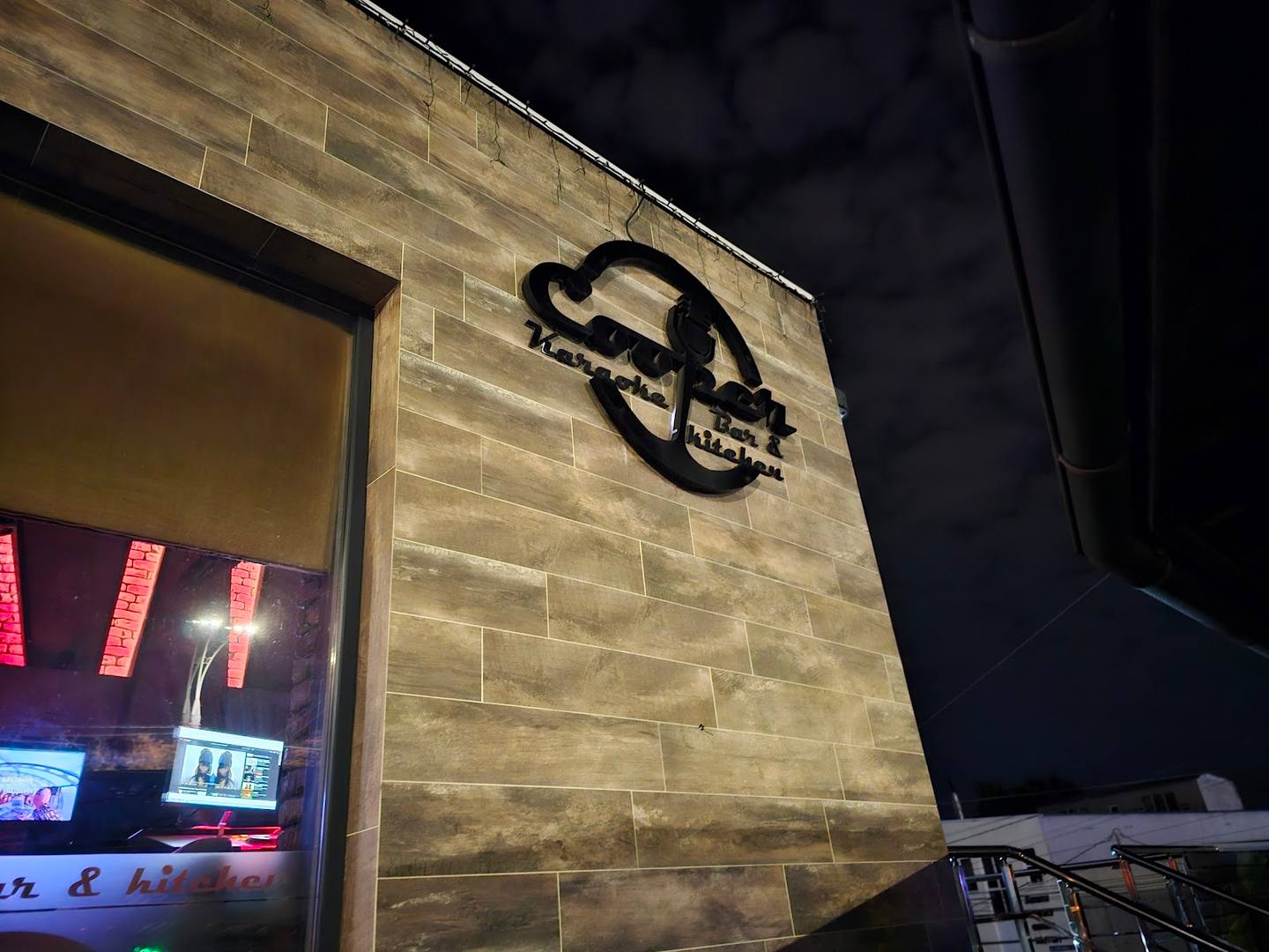 Neon-lit venue sign on brick exterior at night