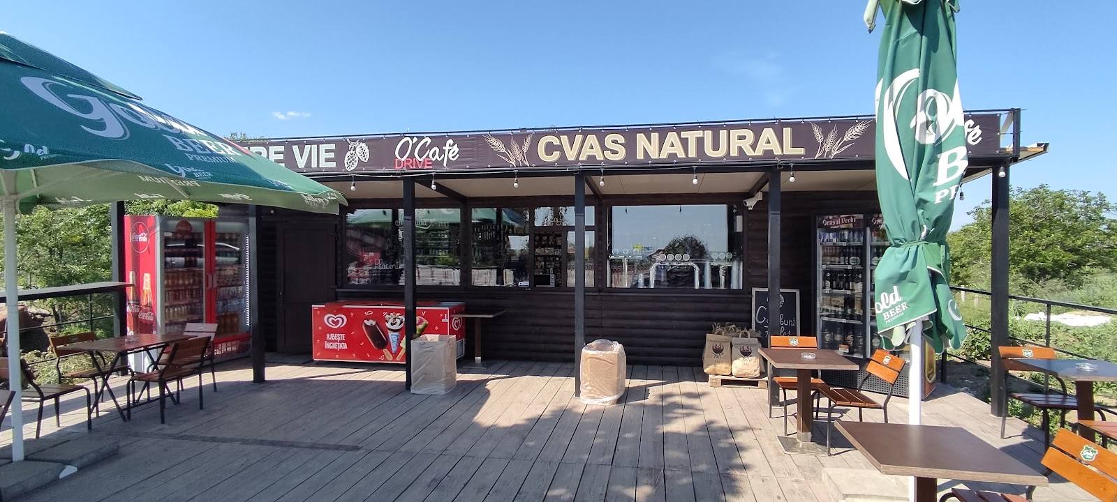 Natural wine bar storefront with mountain backdrop, outdoor seating and signage visible