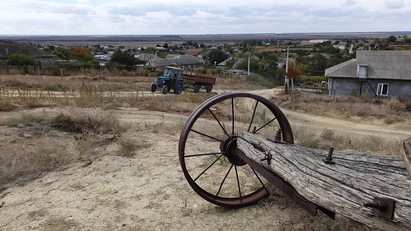 Old wagon wheel overlooking rural Moldovan farmland and countryside landscape