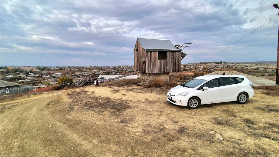 Rustic wooden structure with electric vehicle on remote hilltop property