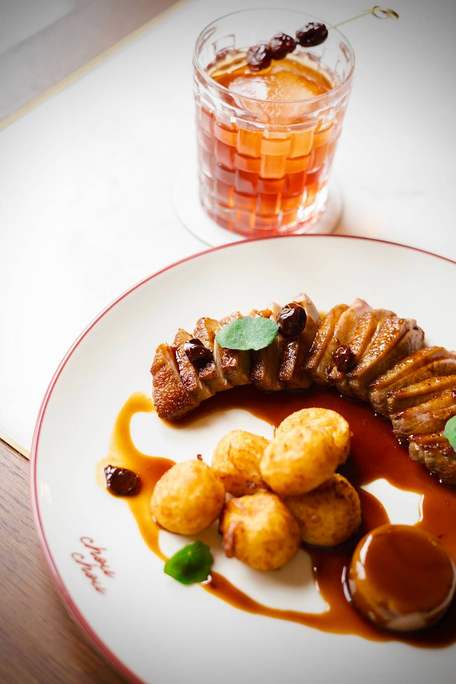 Plated meat dish with roasted potatoes and caramel sauce