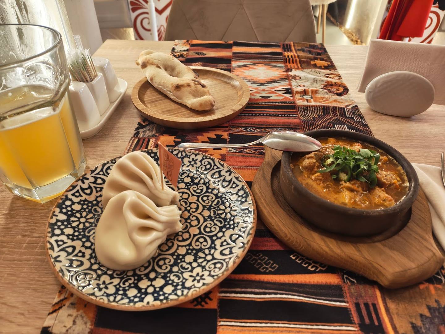 Dumplings and baked dish on patterned plates at table setting