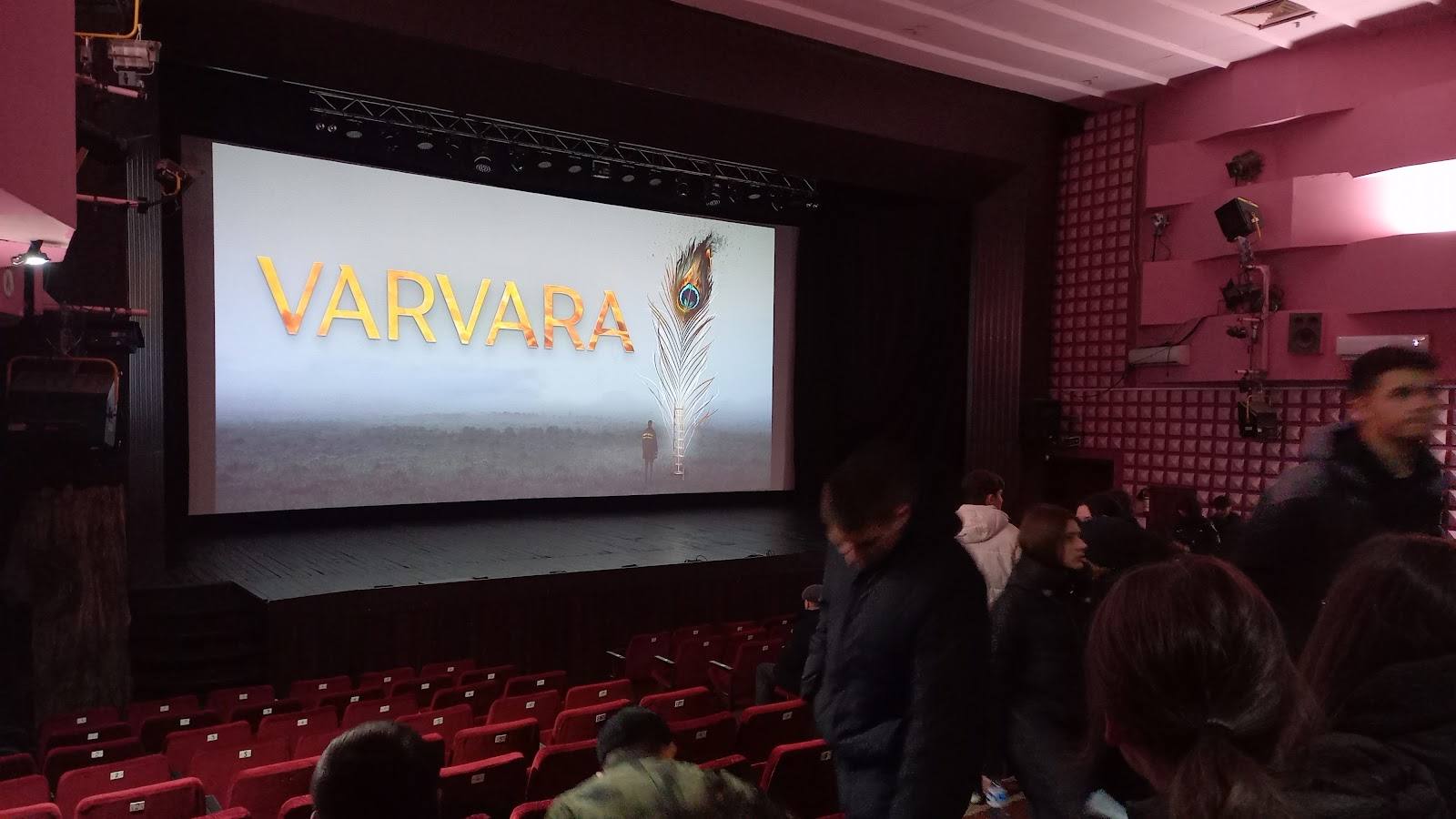 Cinema interior with red seats and VARVARA film projected on screen