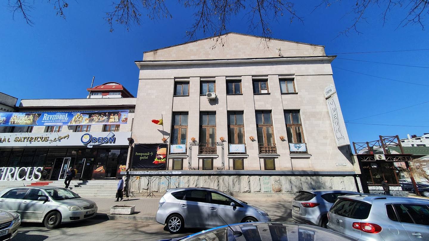 Neoclassical government or civic building with columned facade and parked cars in forecourt