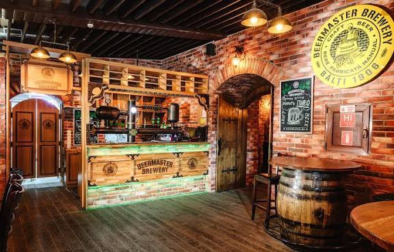 Craft brewery interior with wooden service counter, brick walls, and branded signage