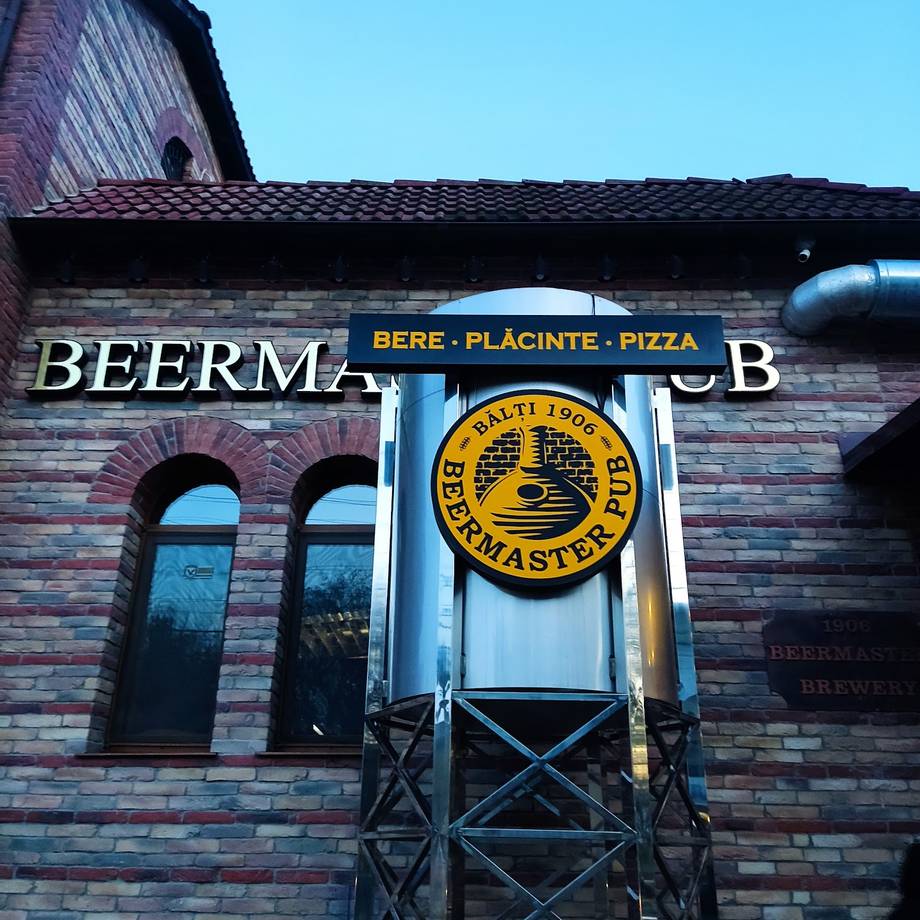 Beerm brick facade with beer, craft, and pizza signage and yellow brewery logo
