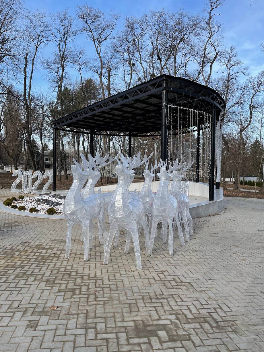 Outdoor terrace pavilion with dining setup and decorative white chairs in winter
