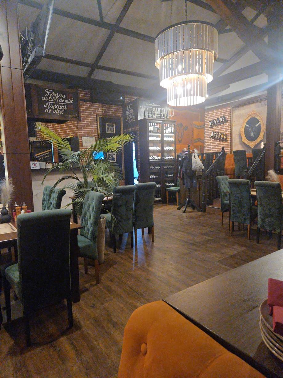 Modern bistro interior with decorative chandelier, black furniture, and ambient lighting