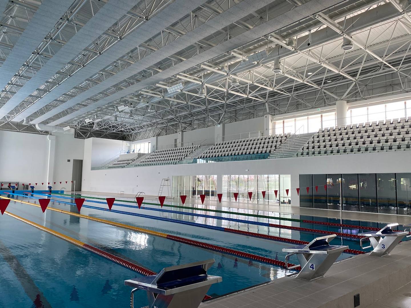 Olympic-size indoor swimming pool with lane dividers and modern facility infrastructure