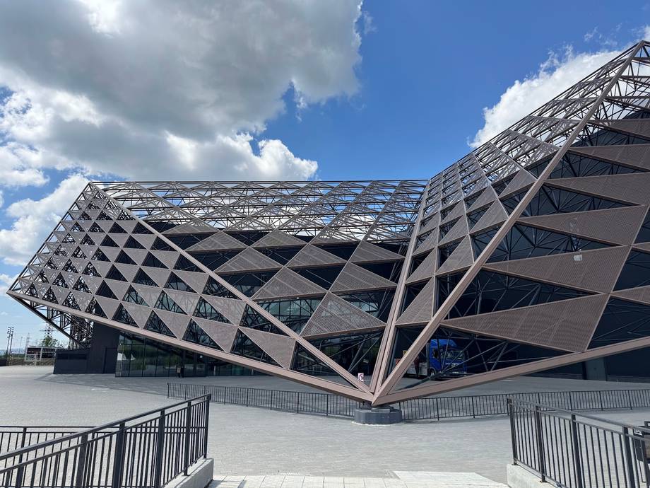 Modern architectural venue with distinctive tilted geometric facade and open plaza