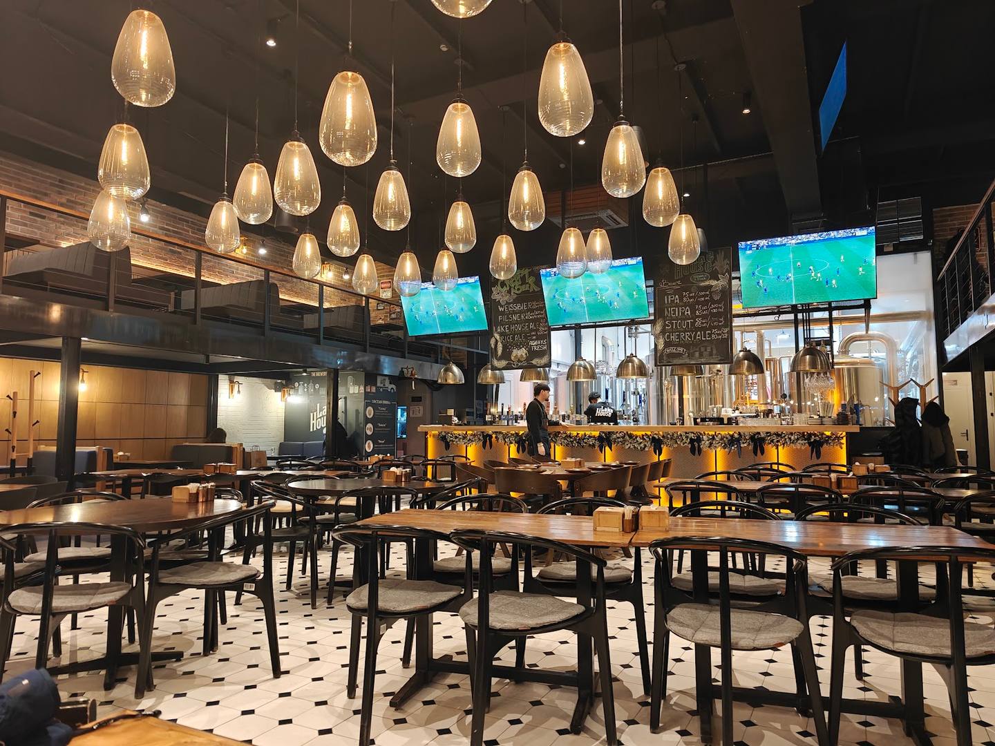 Modern restaurant dining room with suspended pendant lighting and floor-to-ceiling windows