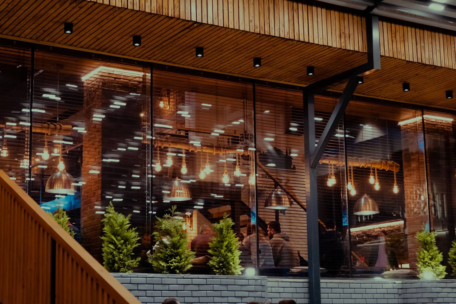 Modern storefront with wood and brick facade, large windows revealing warm interior dining space