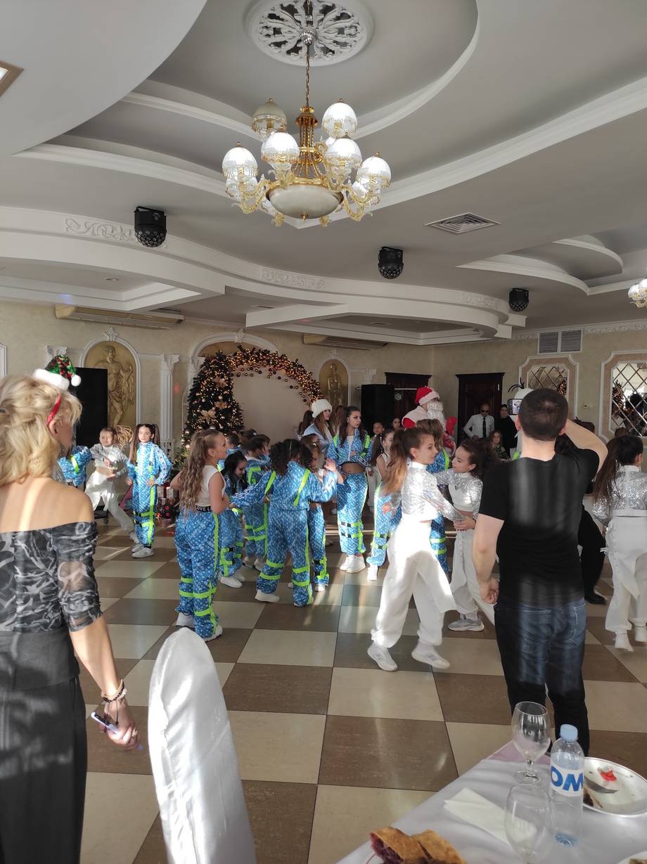 Event reception hall with elegant chandelier, coffered ceiling, and guests during celebration