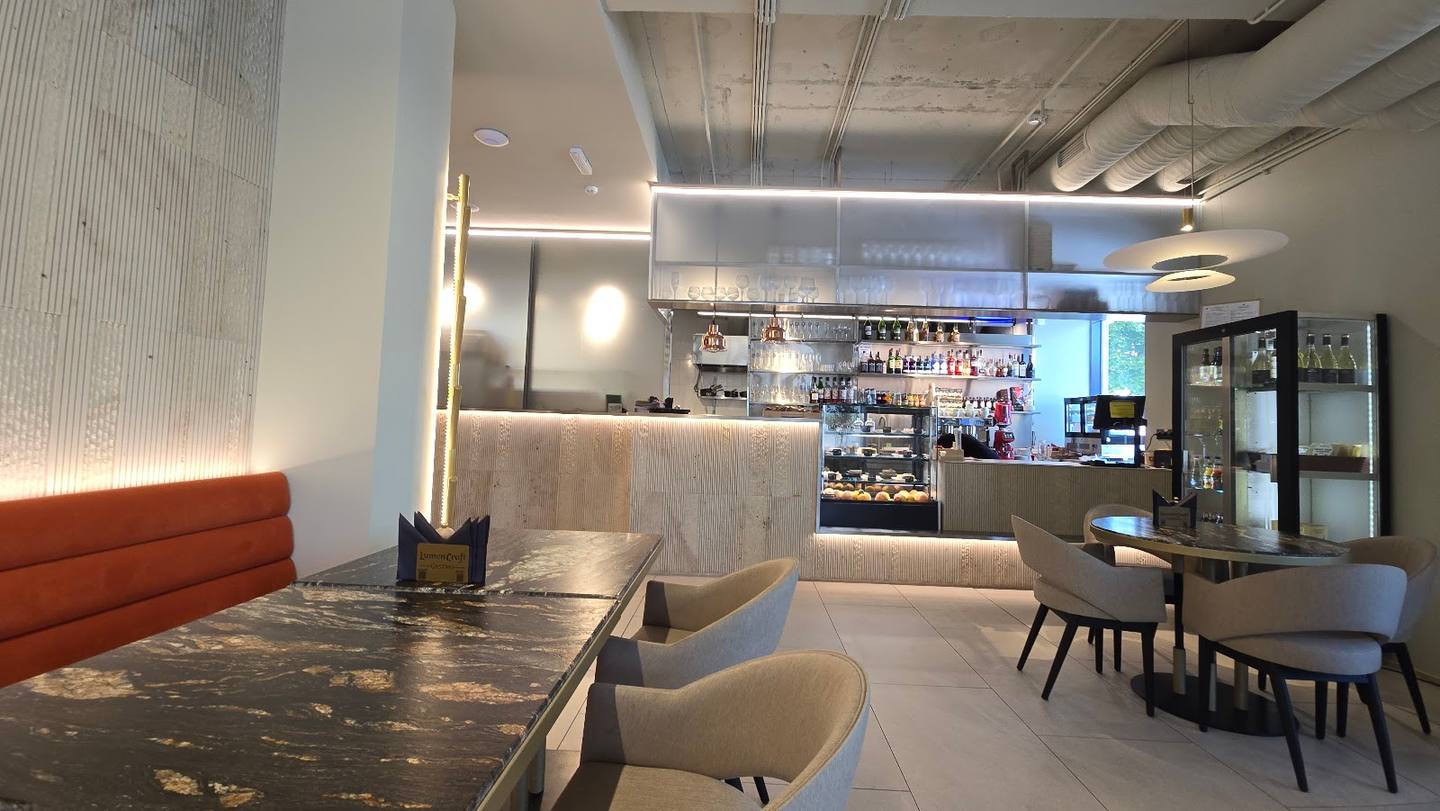 Modern cafe interior with bar counter, dining tables, and contemporary lighting design
