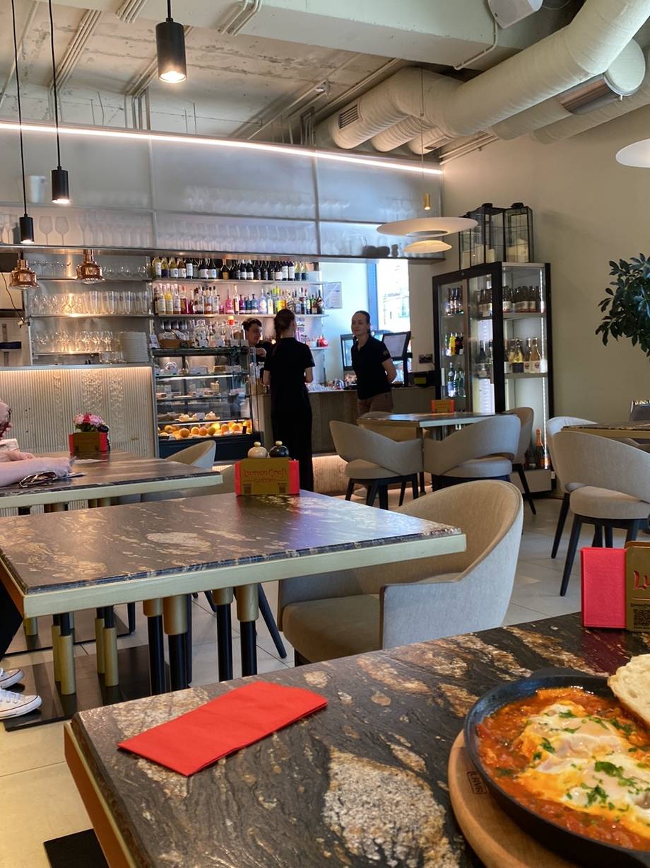 Modern café interior with open kitchen, dining tables, and ambient lighting