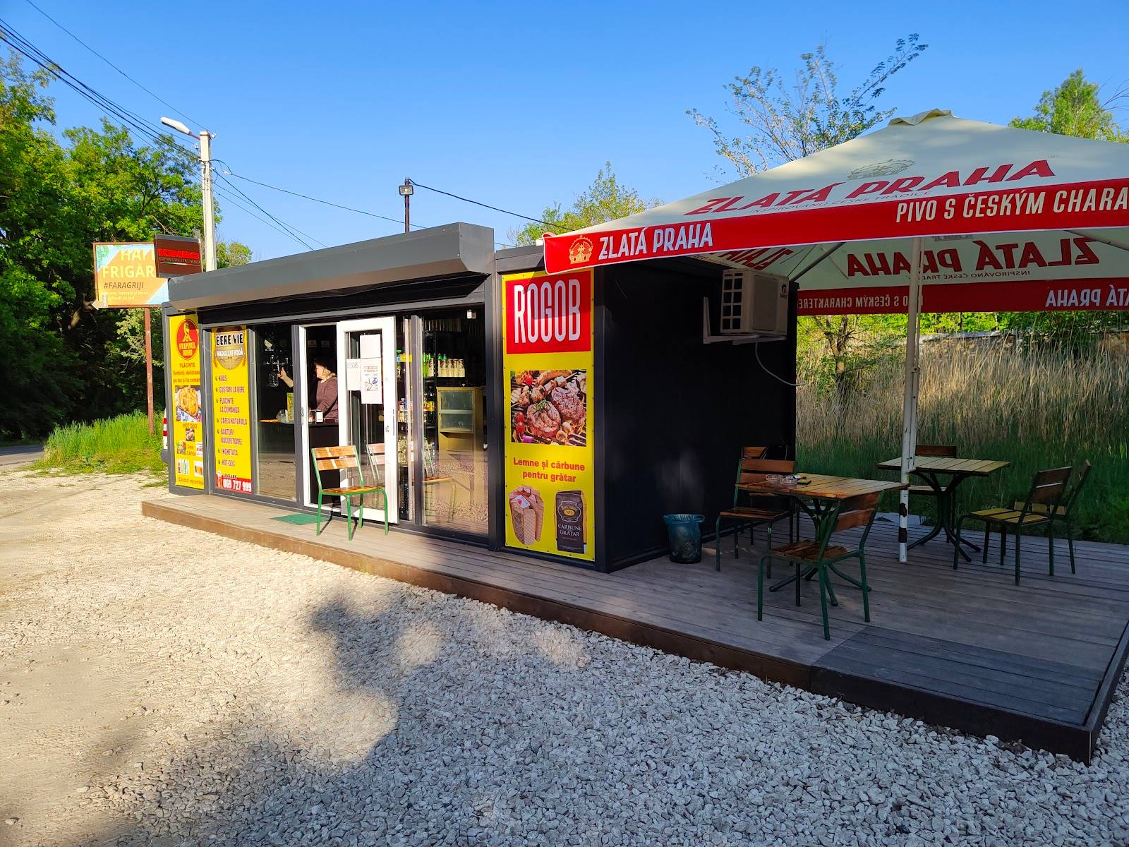Outdoor food kiosk with red signage and covered seating area under awning