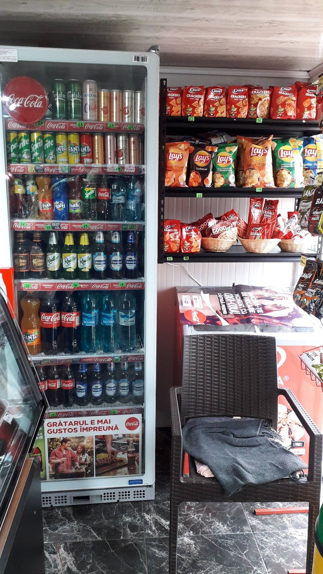 Refrigerated beverage and snack display with Coca-Cola products and packaged goods