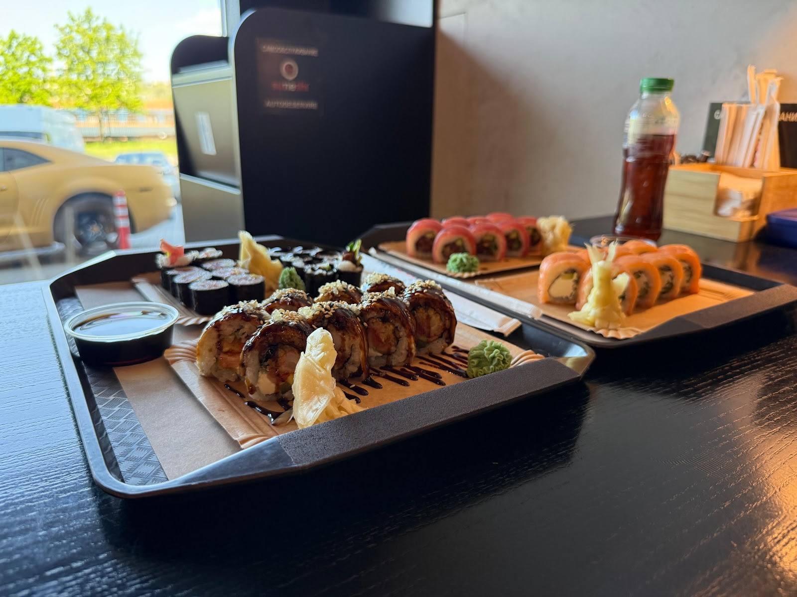 Catering spread with grilled meats, appetizers, and pastries on black trays
