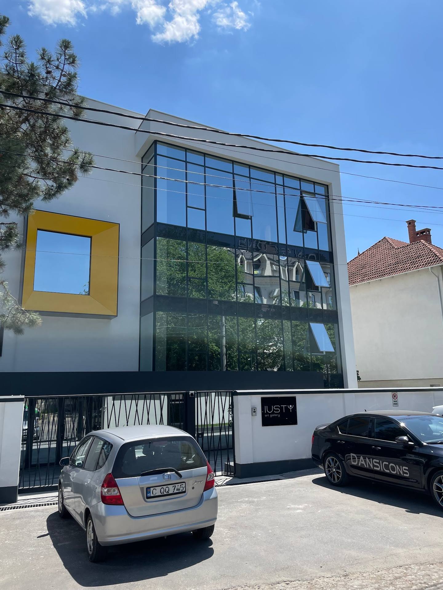 Modern storefront with large glass windows and yellow architectural accent frame