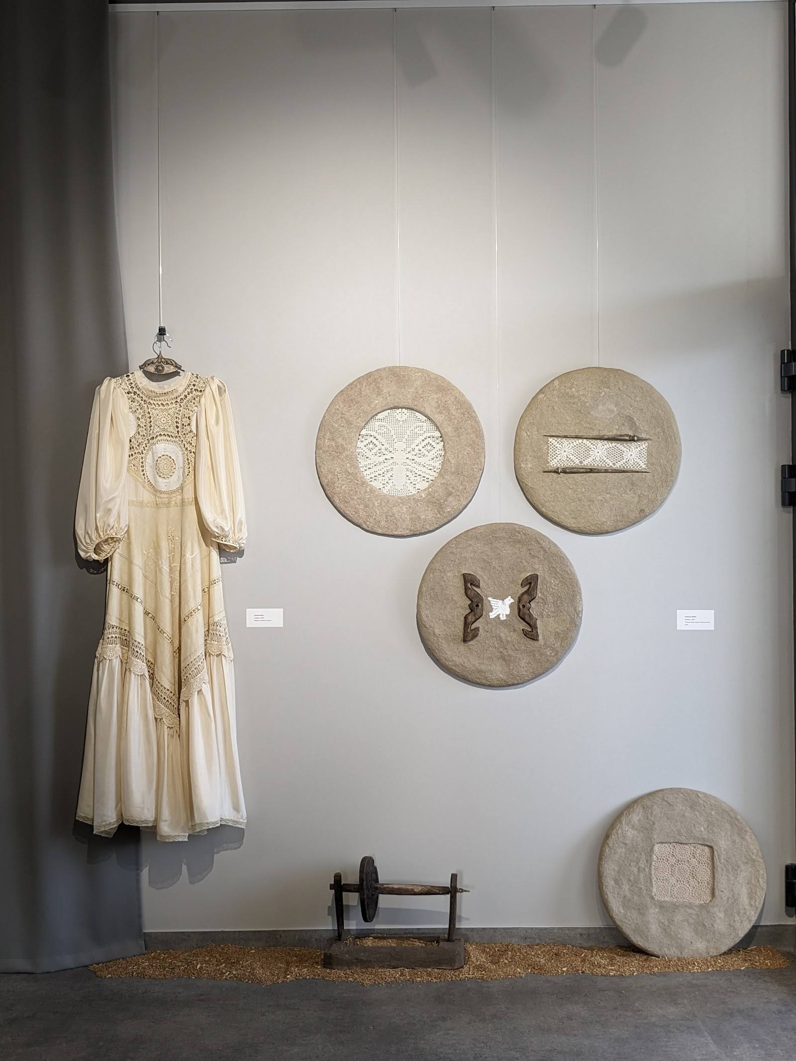 Museum exhibition display with vintage dress and textile art pieces
