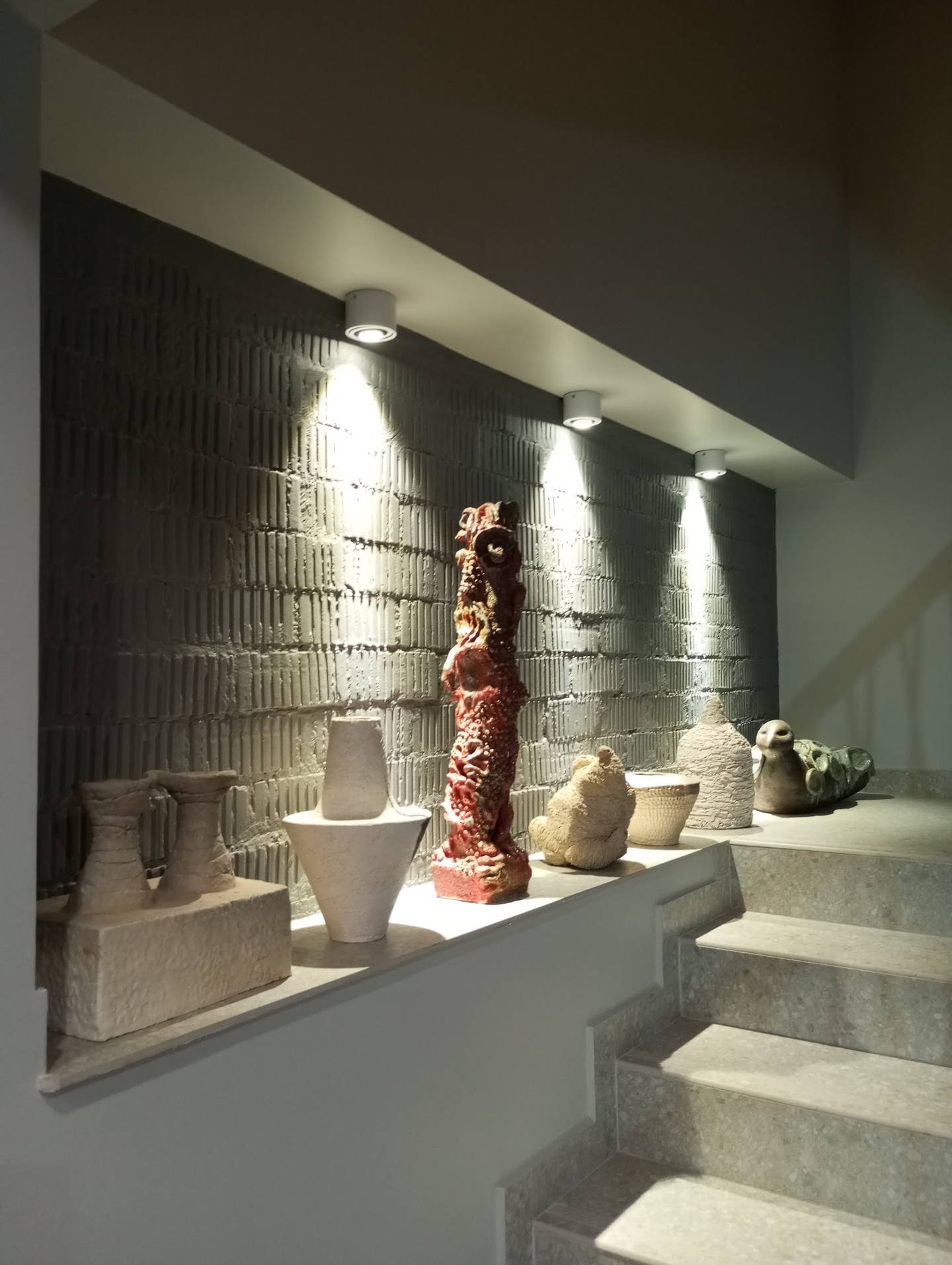 Retail product display with ceramic vessels and decorative item in contemporary showroom