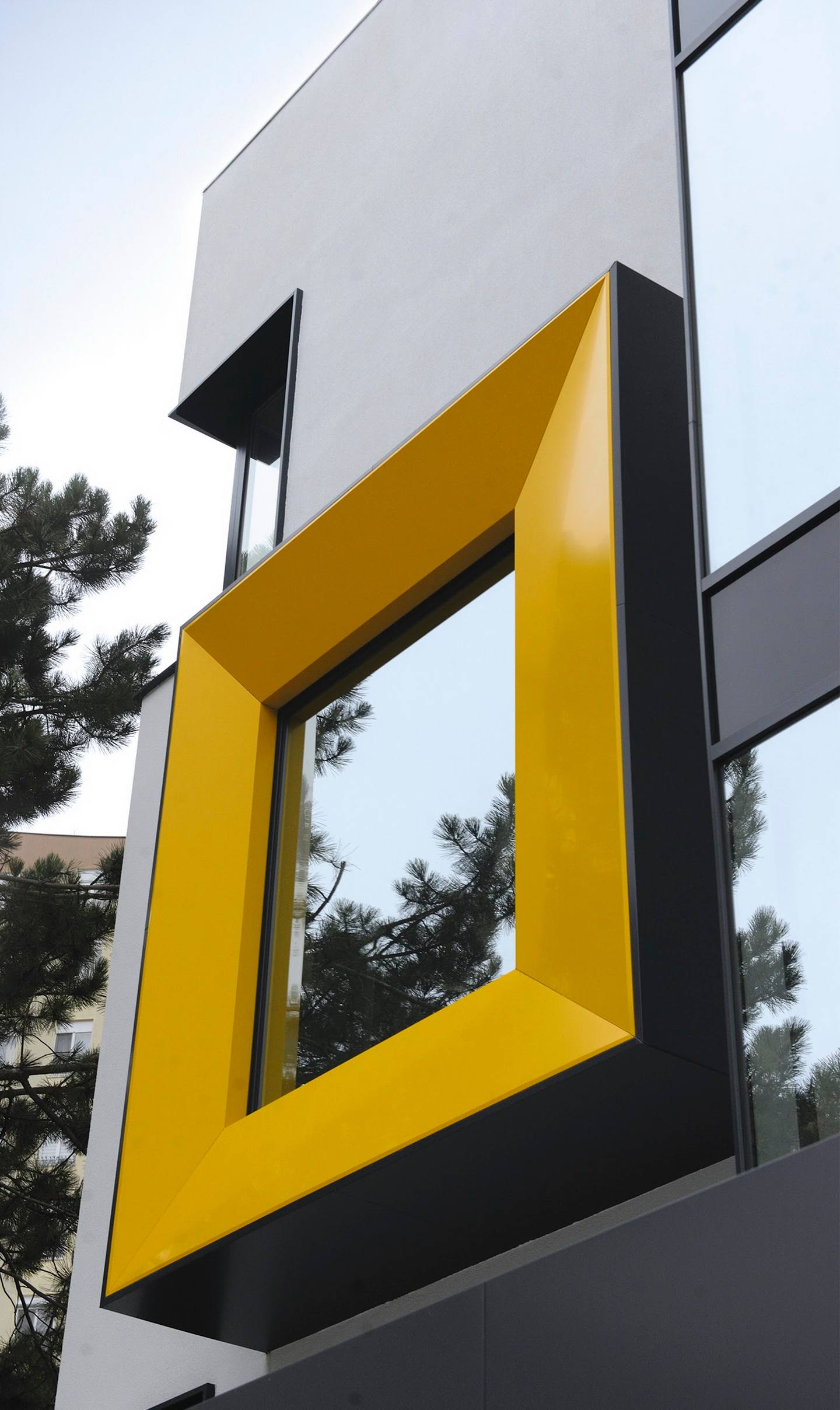 Modern yellow and black geometric signage on building exterior