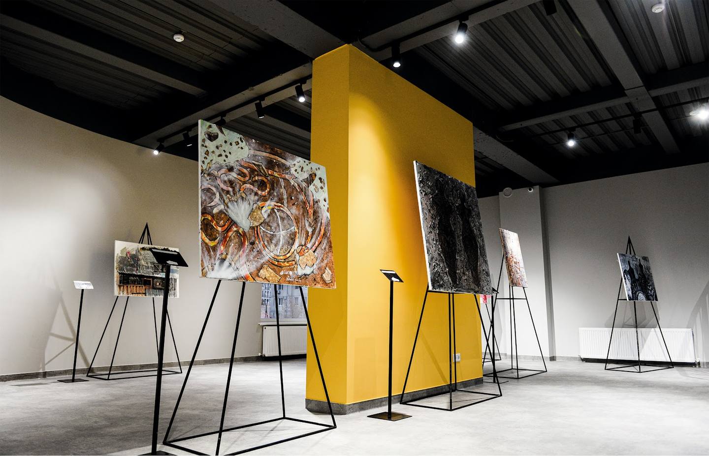 Contemporary art gallery interior with bold yellow installation and minimalist display architecture