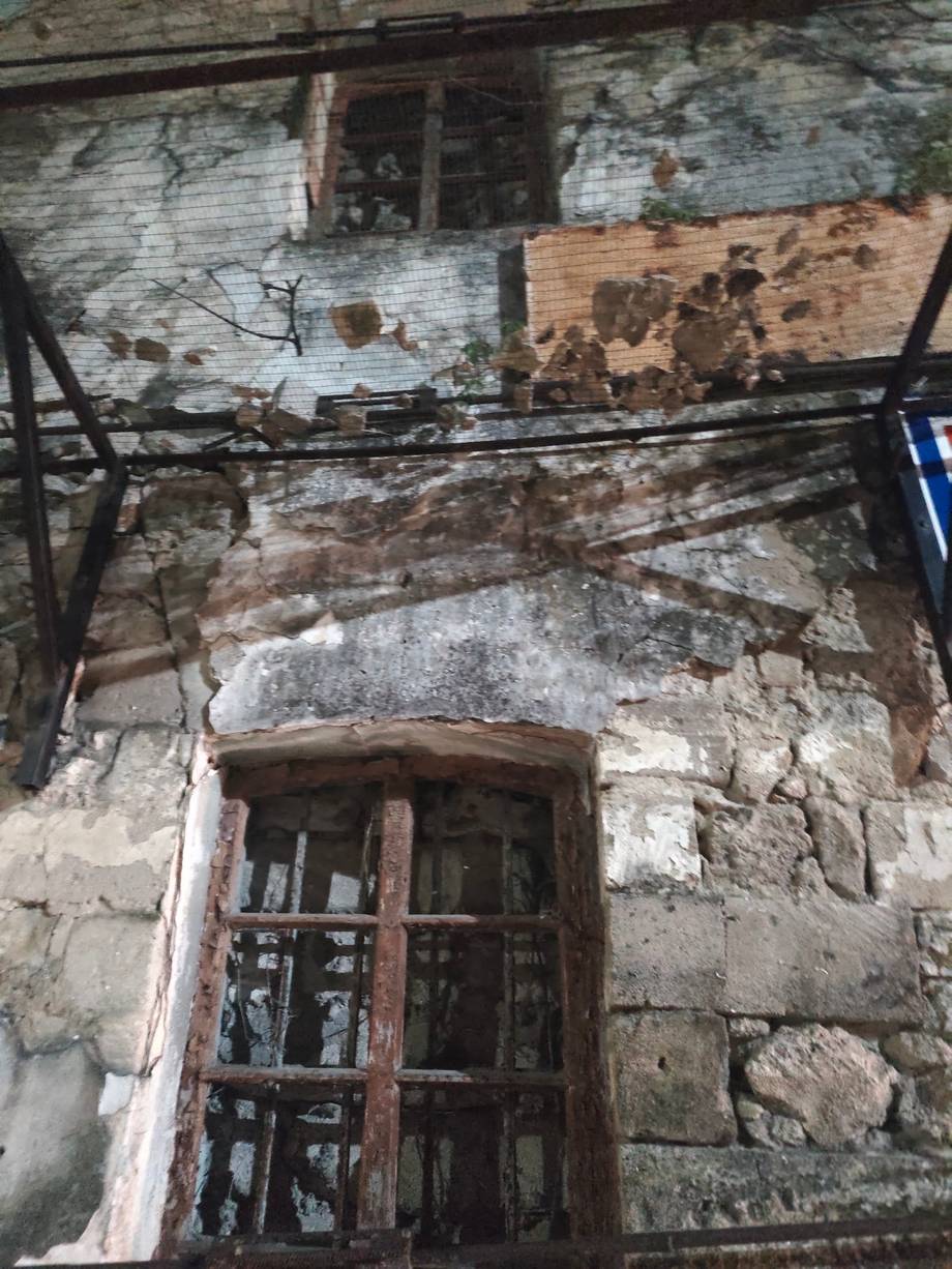 Weathered facade detail with deteriorating plaster and aged wooden door