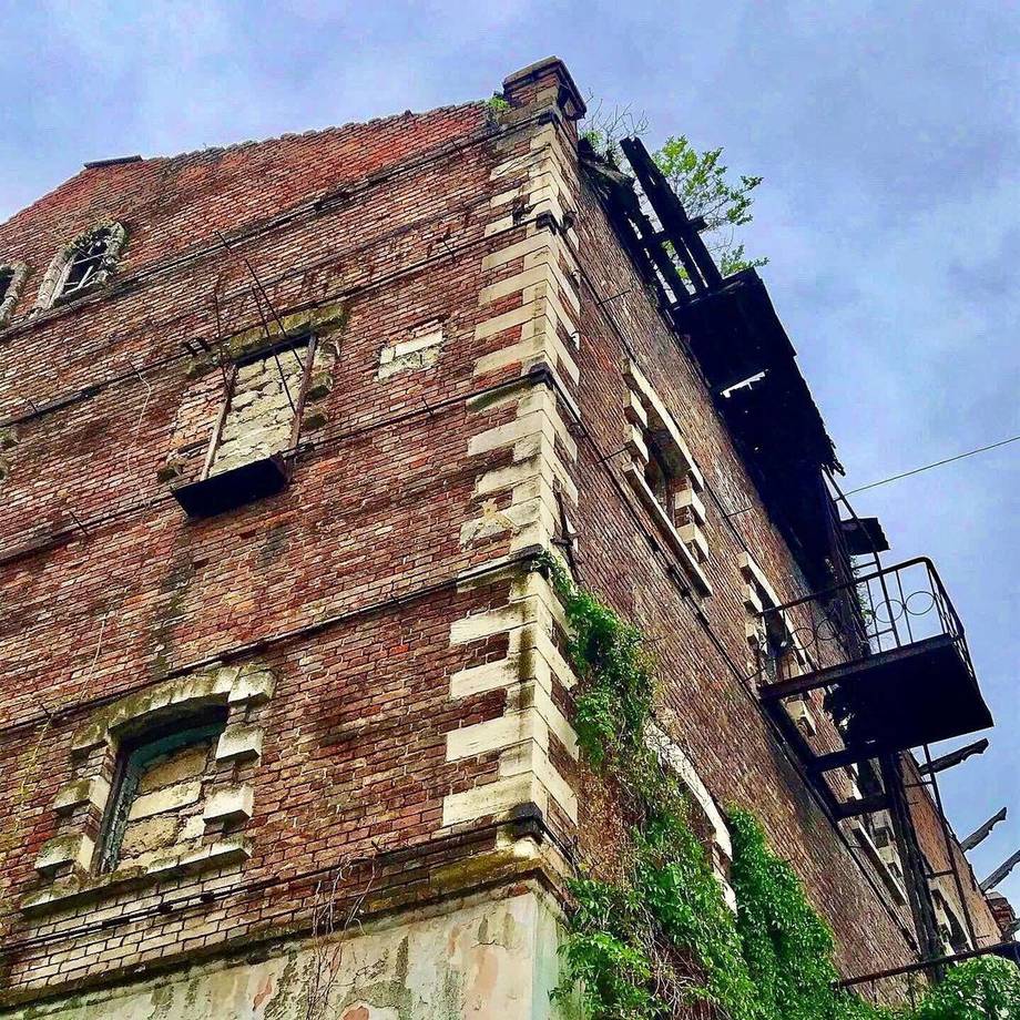 Historic brick building facade with weathered stone details and external stairs